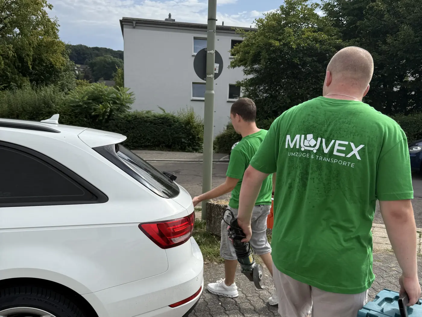 Muvex-Mitarbeiter beladen ein Fahrzeug in einer Wohnstraße — Umzug in Leverkusen