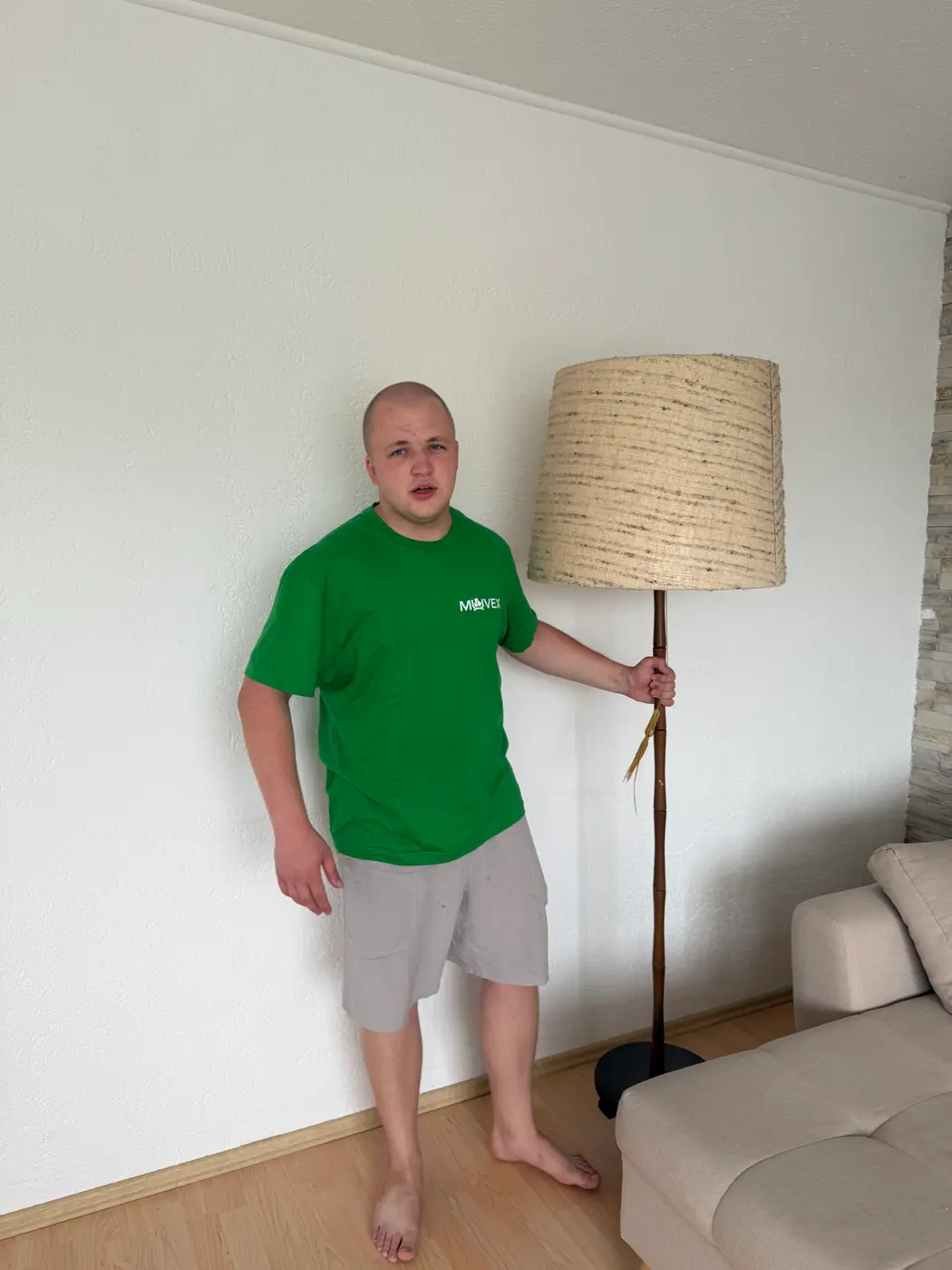 Muvex-Mitarbeiter trägt eine Stehlampe aus dem Wohnzimmer