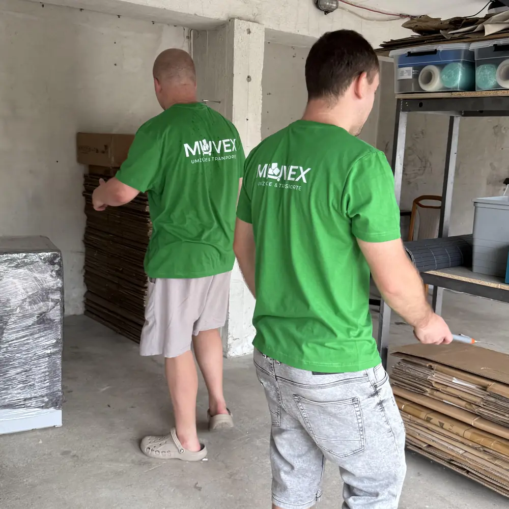 Muvex-Team räumt eine Garage aus und trägt Sperrmüll heraus