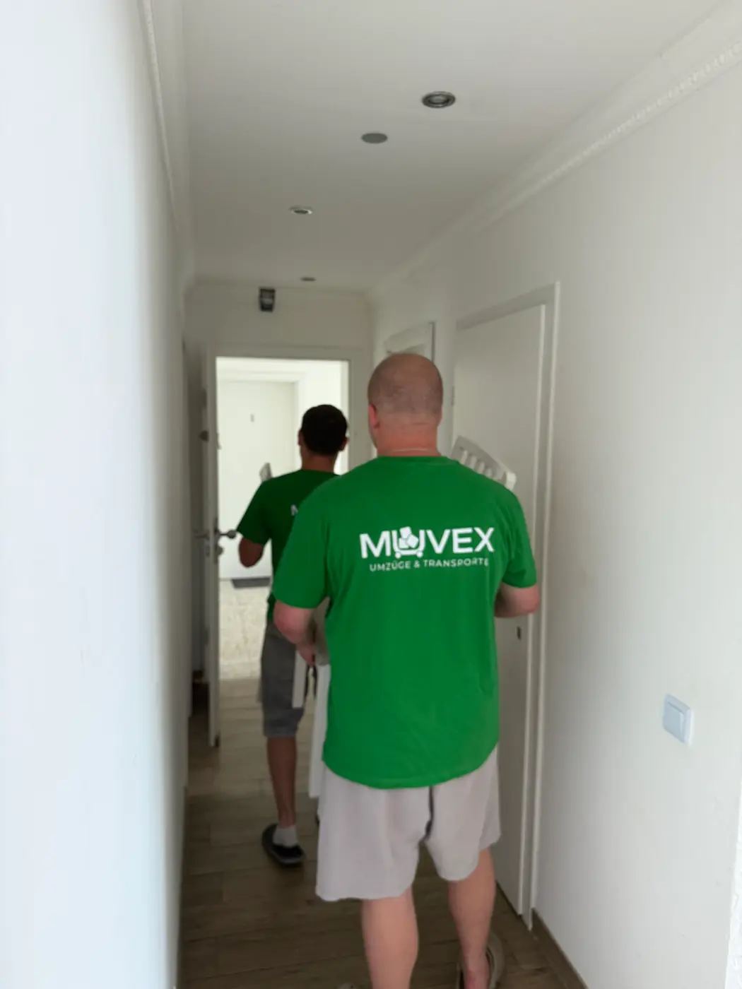 Muvex-Team beim Auszug durch den Flur einer leergeräumten Wohnung